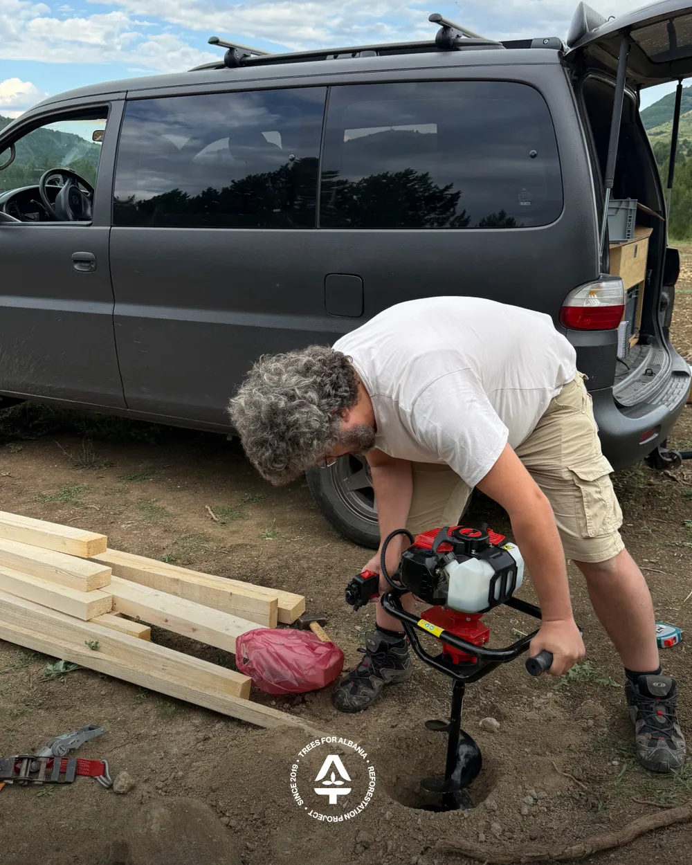 Flori drilling the holes for the supporting poles