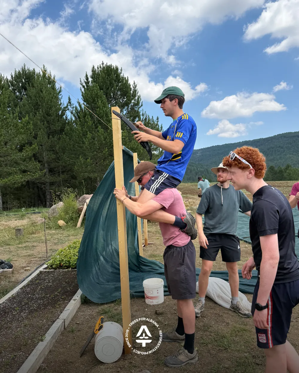 The boys being boys having fun cutting the poles to size